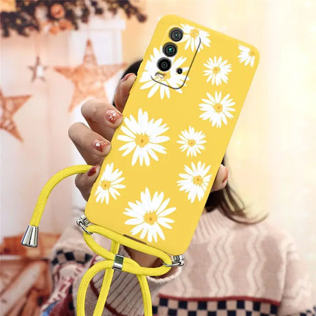 a woman holding a yellow phone case with white flowers on it