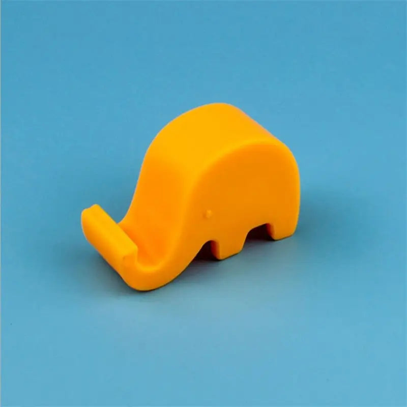 a yellow plastic elephant toy on a blue background