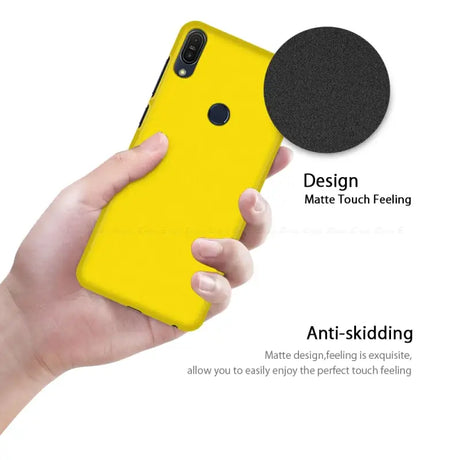 The back of a yellow iphone case with a black circle on it