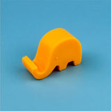 a yellow plastic elephant toy on a blue background