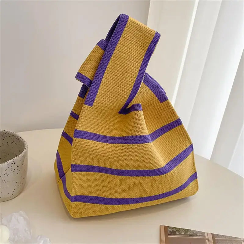 a yellow and purple bag sitting on a table