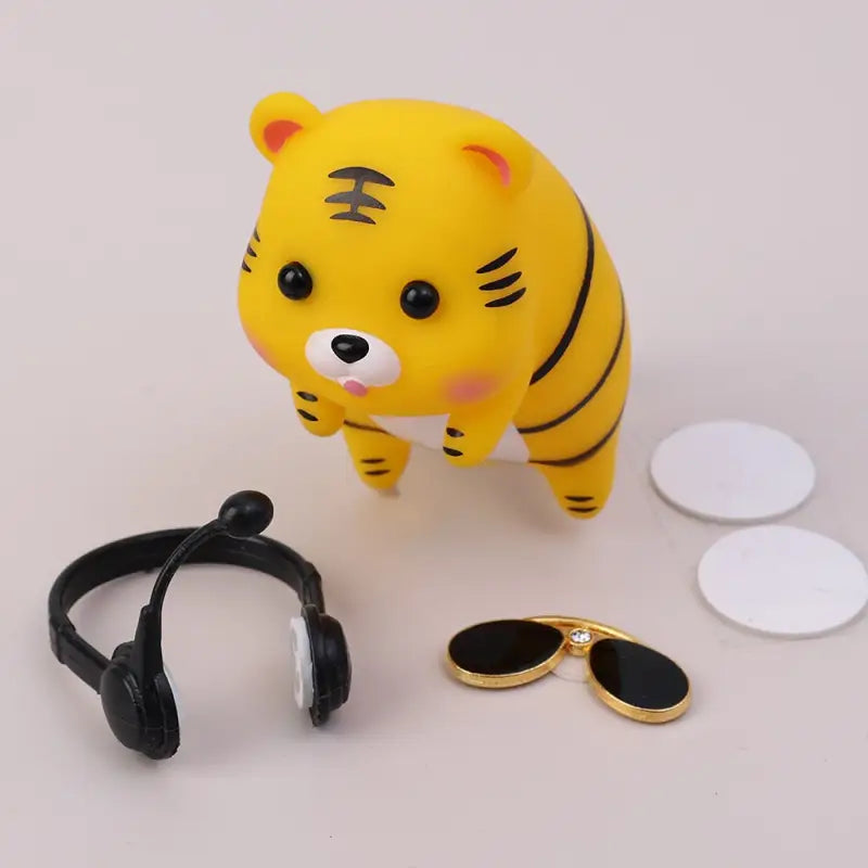 a yellow tiger toy with a ring and a pair of sunglasses