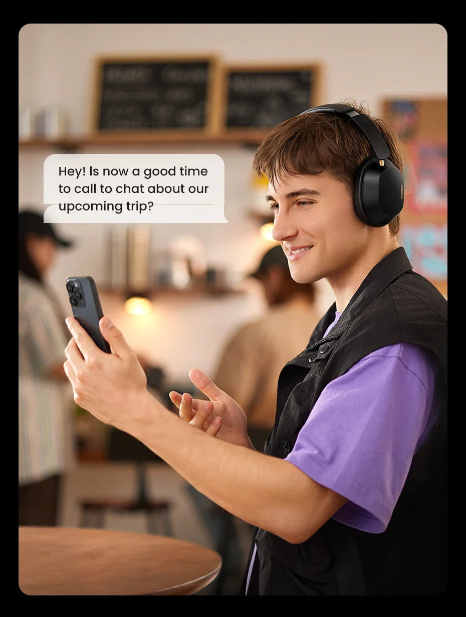 Smiling young person wearing headphones and looking at a smartphone.